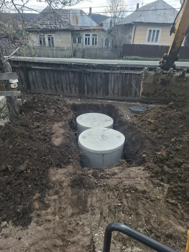 Fosa așezată în groapă, cu capacele aduse la nivelul pământului.