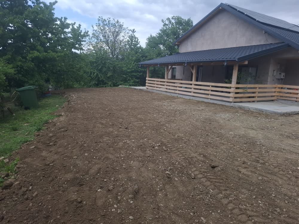 Curte nivelată în fața casei, gata pentru piatră sau pentru gazon.
