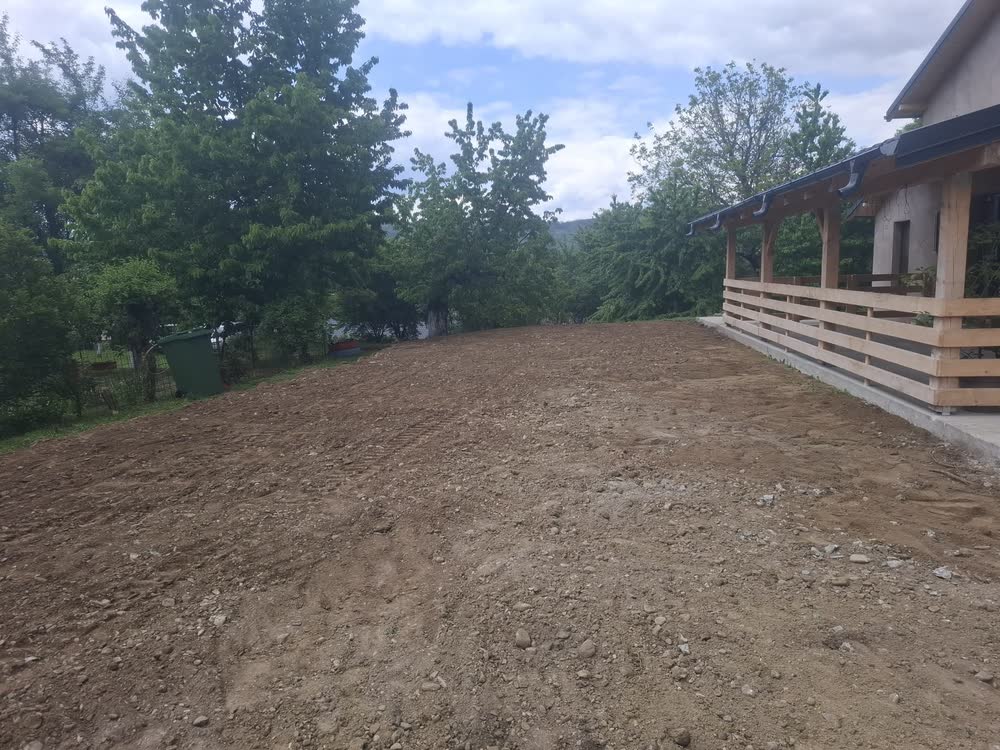 Curte nivelată lângă casă, pregătită pentru amenajare.